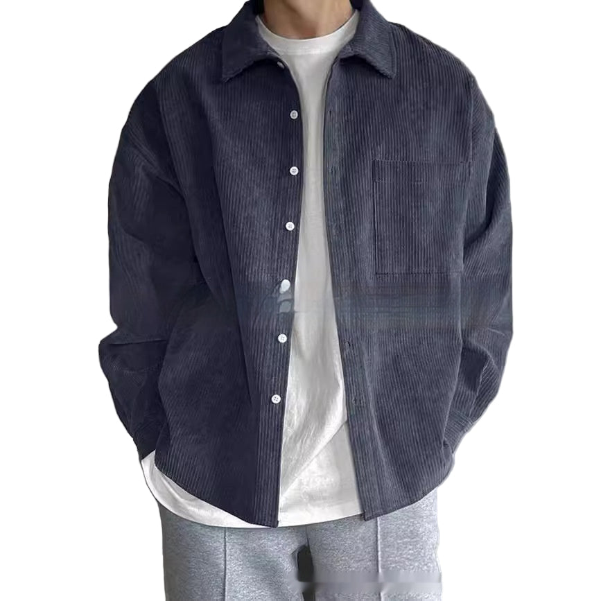 Person wearing a dark blue corduroy shirt over a white shirt with a neutral background