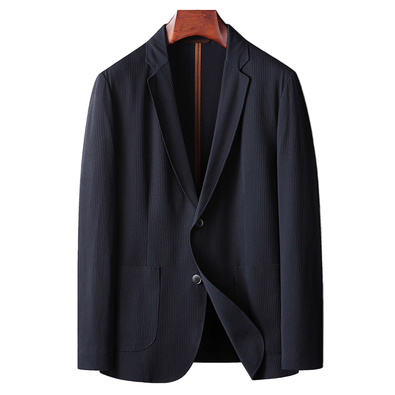 Dark blue blazer on a wooden hanger against a gray background