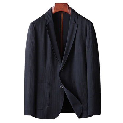 Dark blue blazer on a wooden hanger against a gray background
