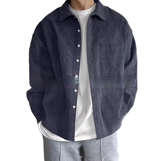 Person wearing a dark blue corduroy shirt over a white shirt with a neutral background