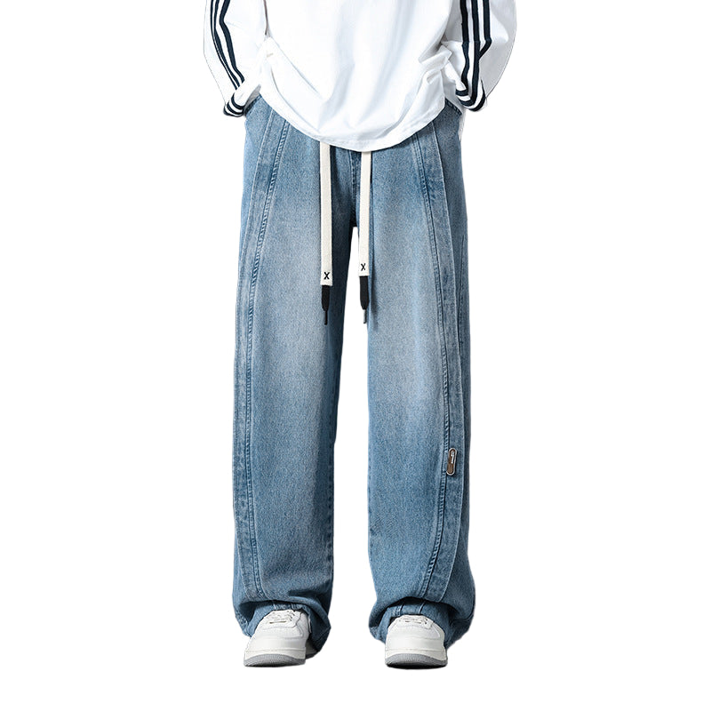 Person wearing light blue jeans and a white hoodie with black stripes on a dark background