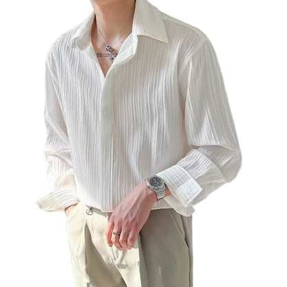 Person wearing a white textured shirt and beige pants against a plain background