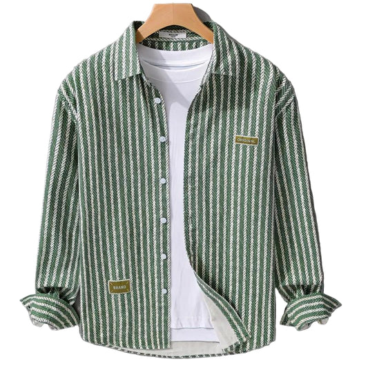 Green and white striped shirt on a hanger against a gray background