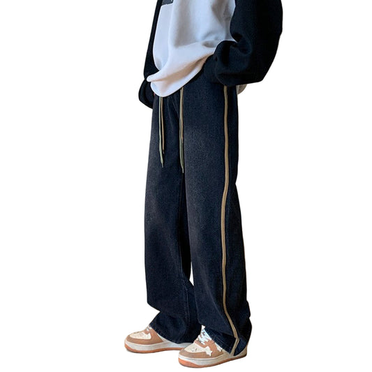 Person wearing black pants with a white shirt and sneakers indoors.