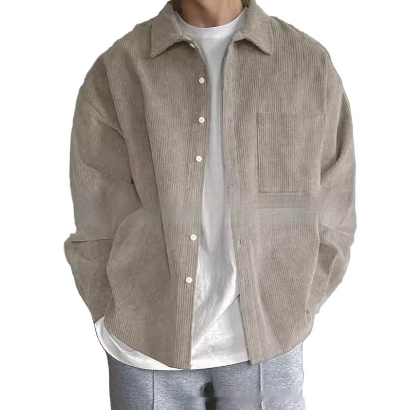 Person wearing a beige corduroy shirt over a white shirt with a plain background