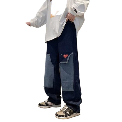 Person wearing a white shirt and blue jeans with a heart design.